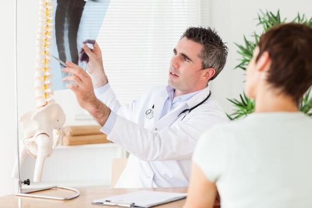 gydytojas parodo stuburo pažeidimą dėl gimdos kaklelio osteochondrozės